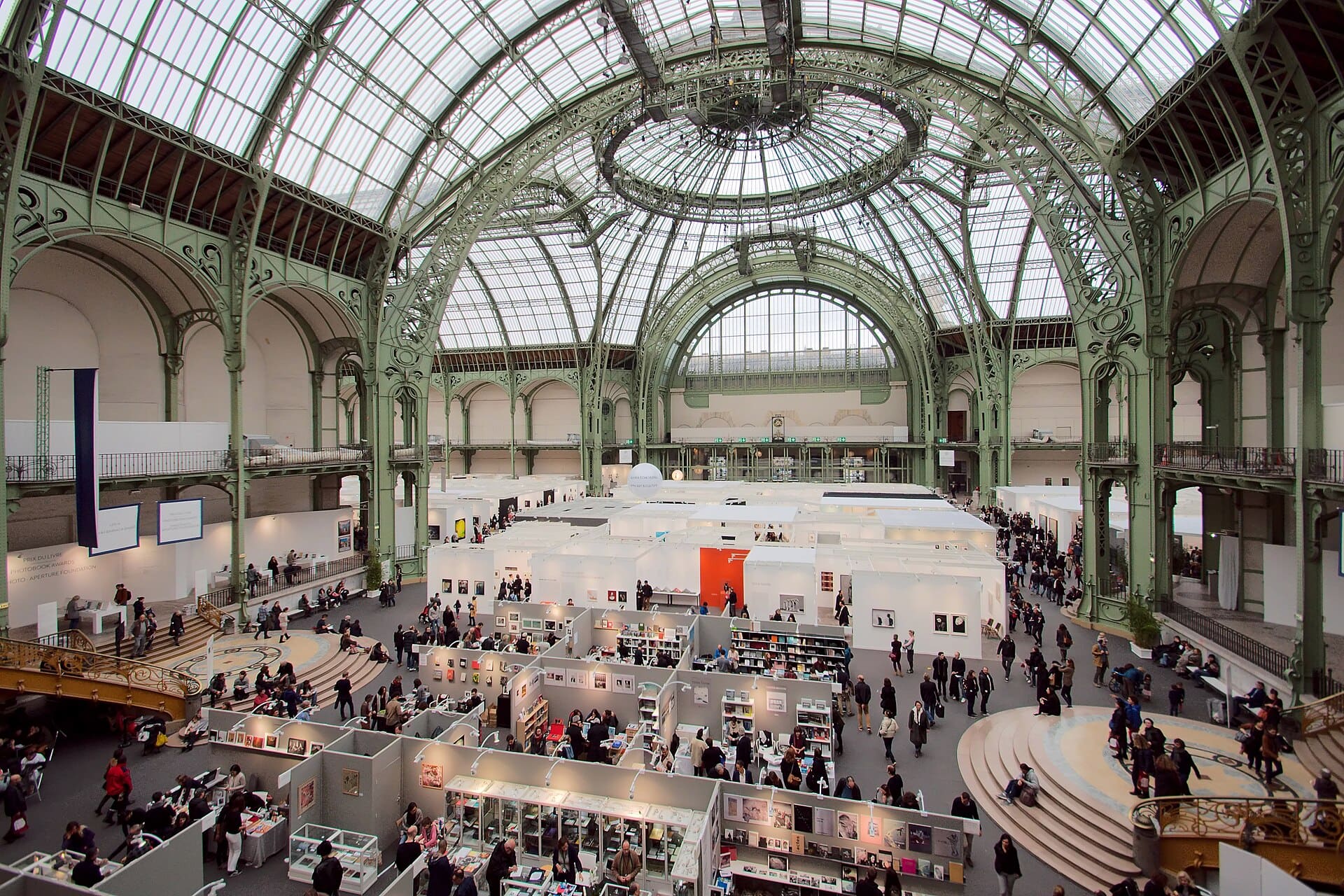 Visiteurs parcourant les stands de galeries sous la verrière du Grand Palais lors de Paris Photo 2016